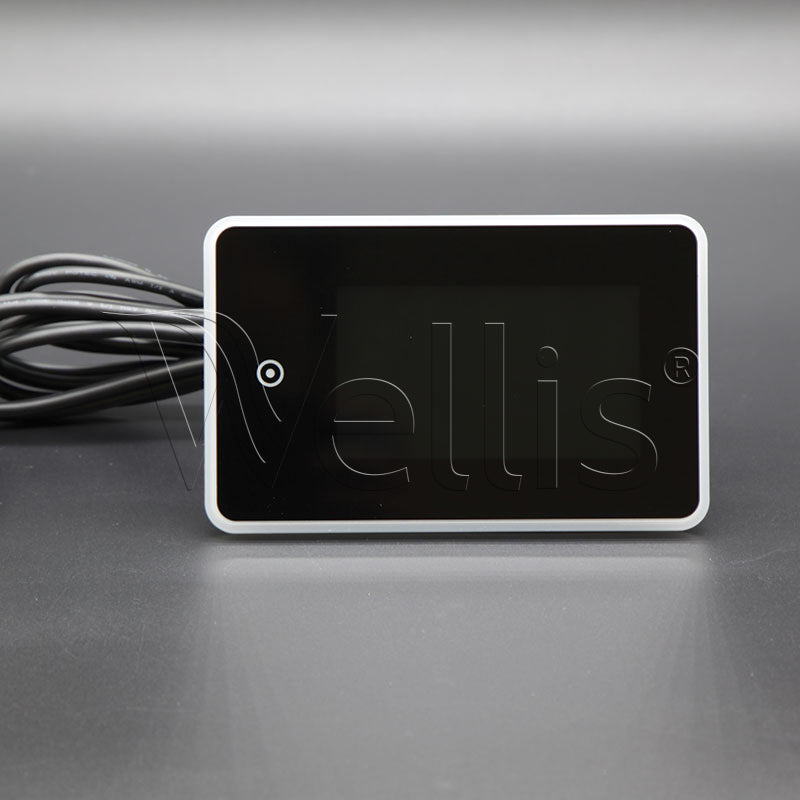 A black rectangular electronic control module with rounded corners, a white border, a black cable on the left, and the brand name 'Wellis' embossed on the front, set against a dark gray background.